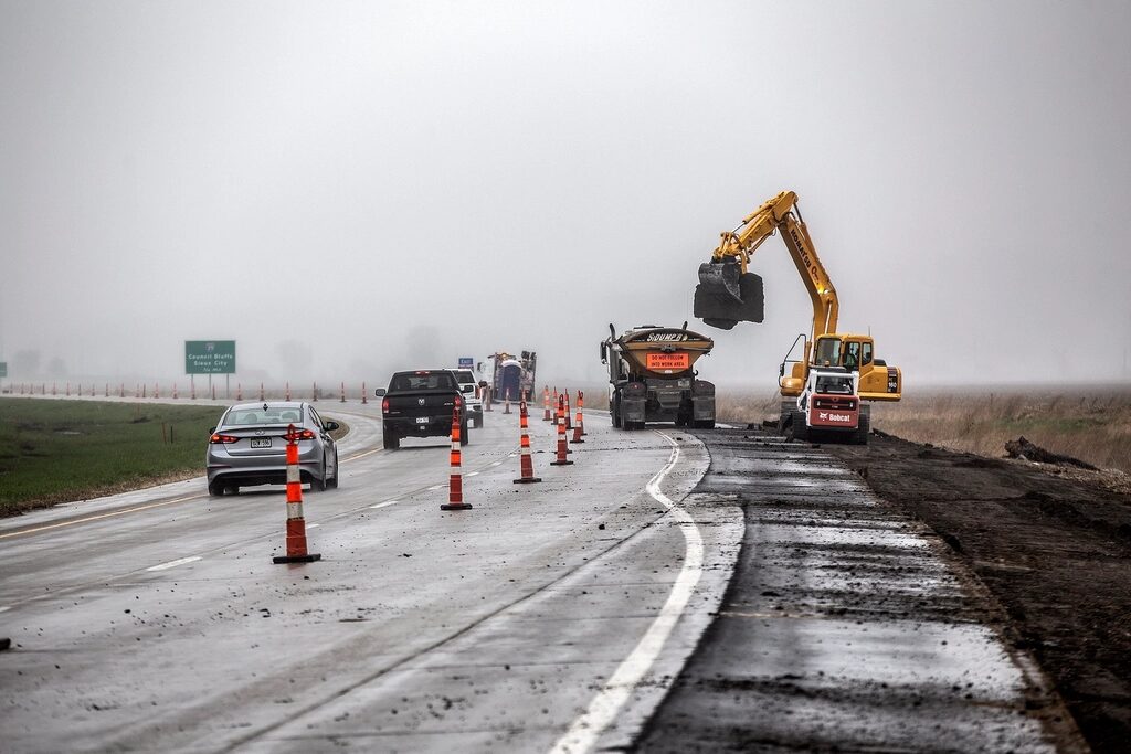Highway works with excavator and traffic cones